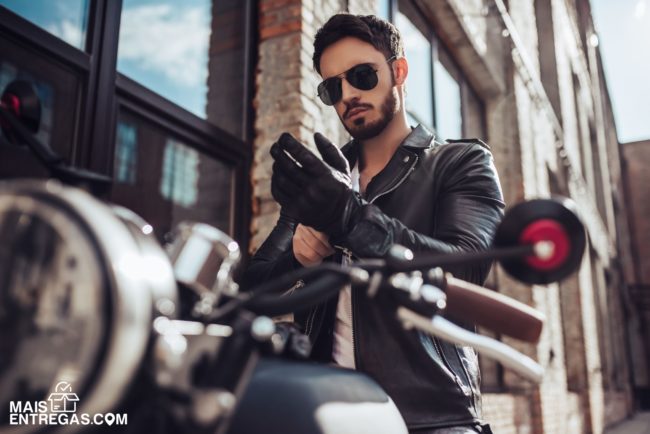 Handsome bearded biker with classic style black motorcycle. Cafe racer.
